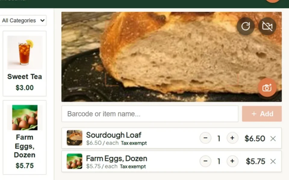 The till with a loaf of bread held up to the camera and the scanned item in the cart